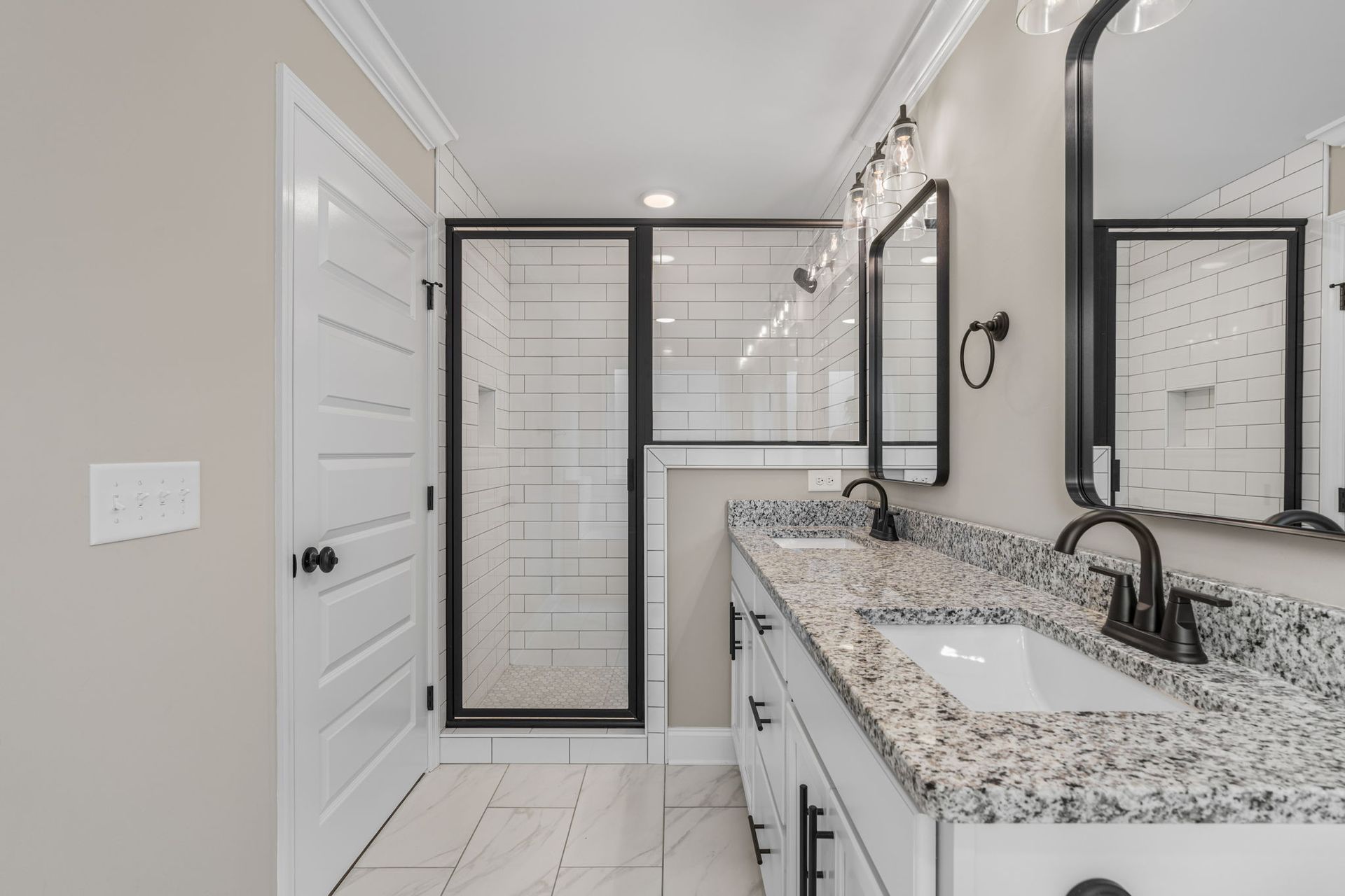 A bathroom with a sink , mirror , and walk in shower.