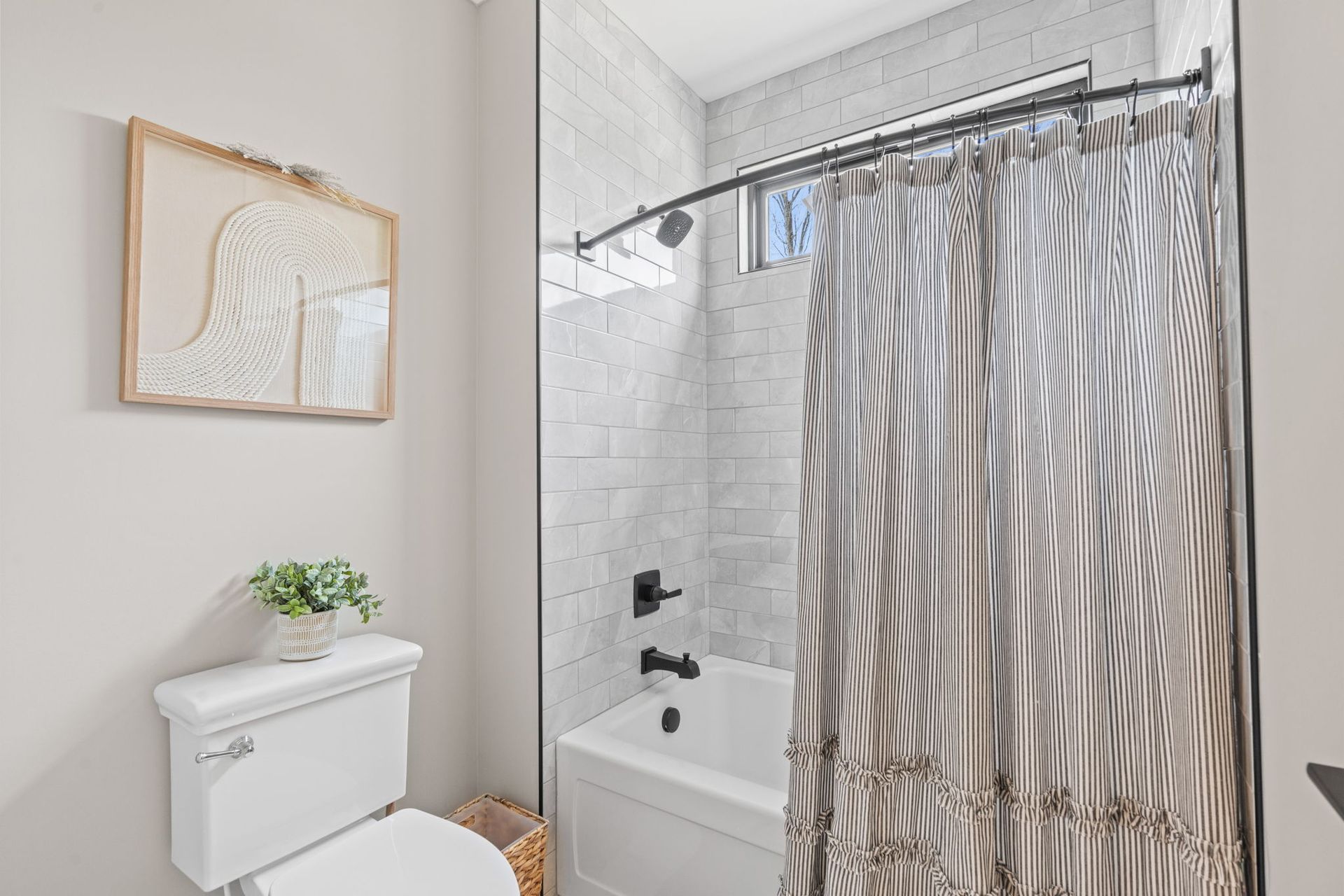 A bathroom with a toilet , bathtub and shower curtain.