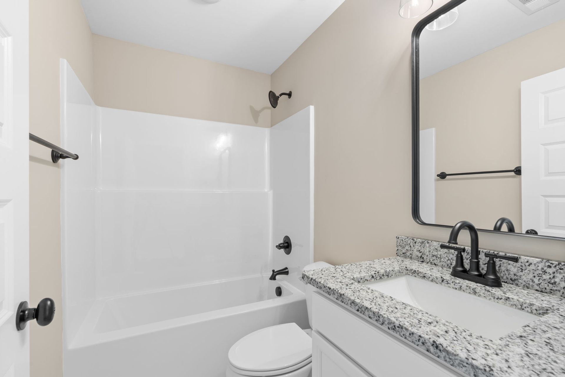 A bathroom with a sink , toilet , bathtub and mirror.