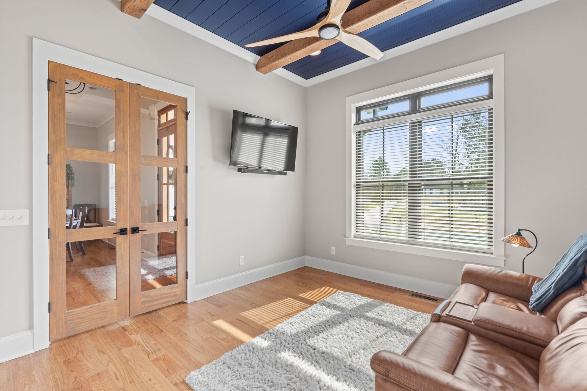 A living room with a couch and a television on the wall.