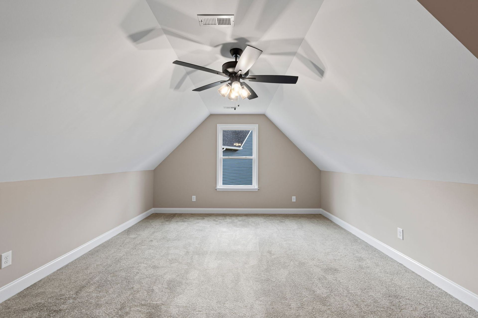 An empty room with a ceiling fan and a window