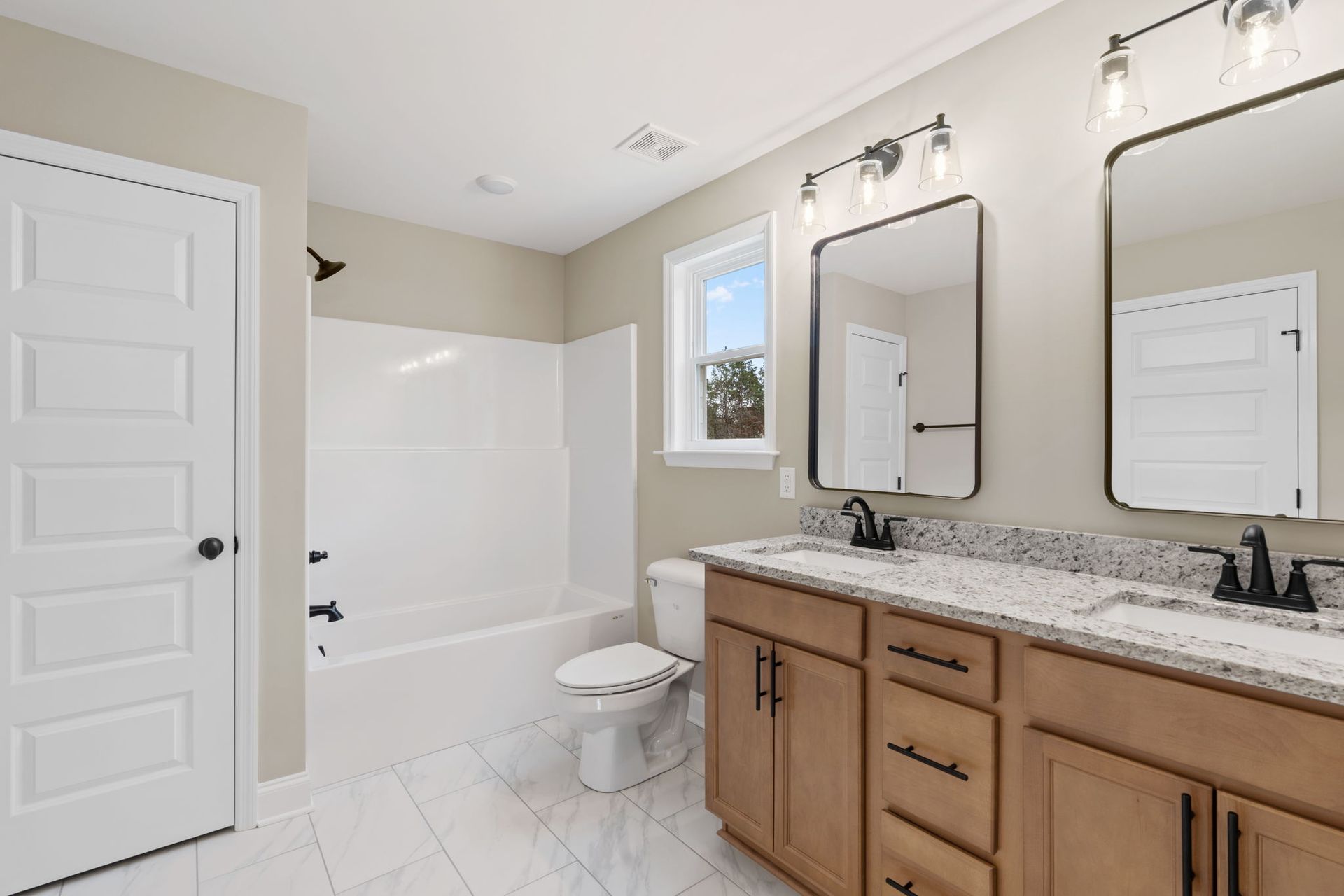 A bathroom with two sinks , a toilet , and a bathtub.