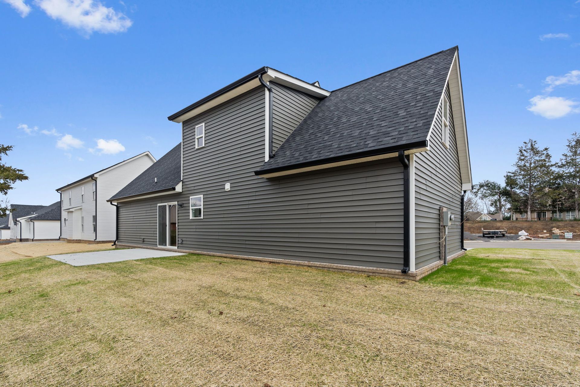 The back of a house with a garage and a lot of grass.