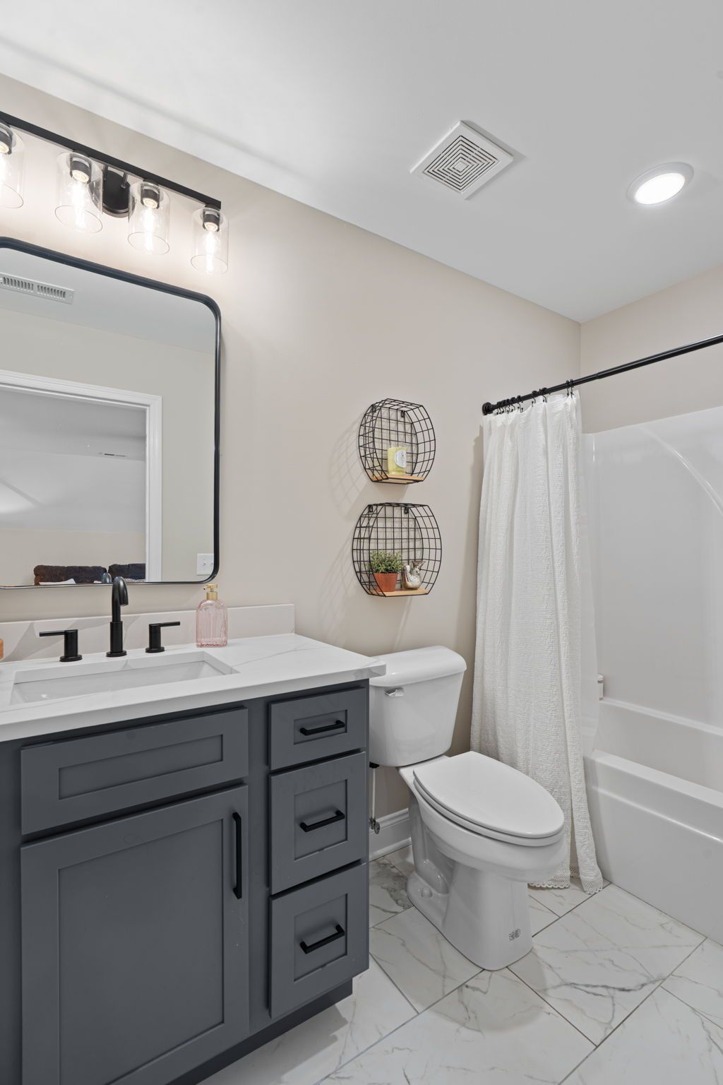 A bathroom with a sink , toilet , tub and mirror.