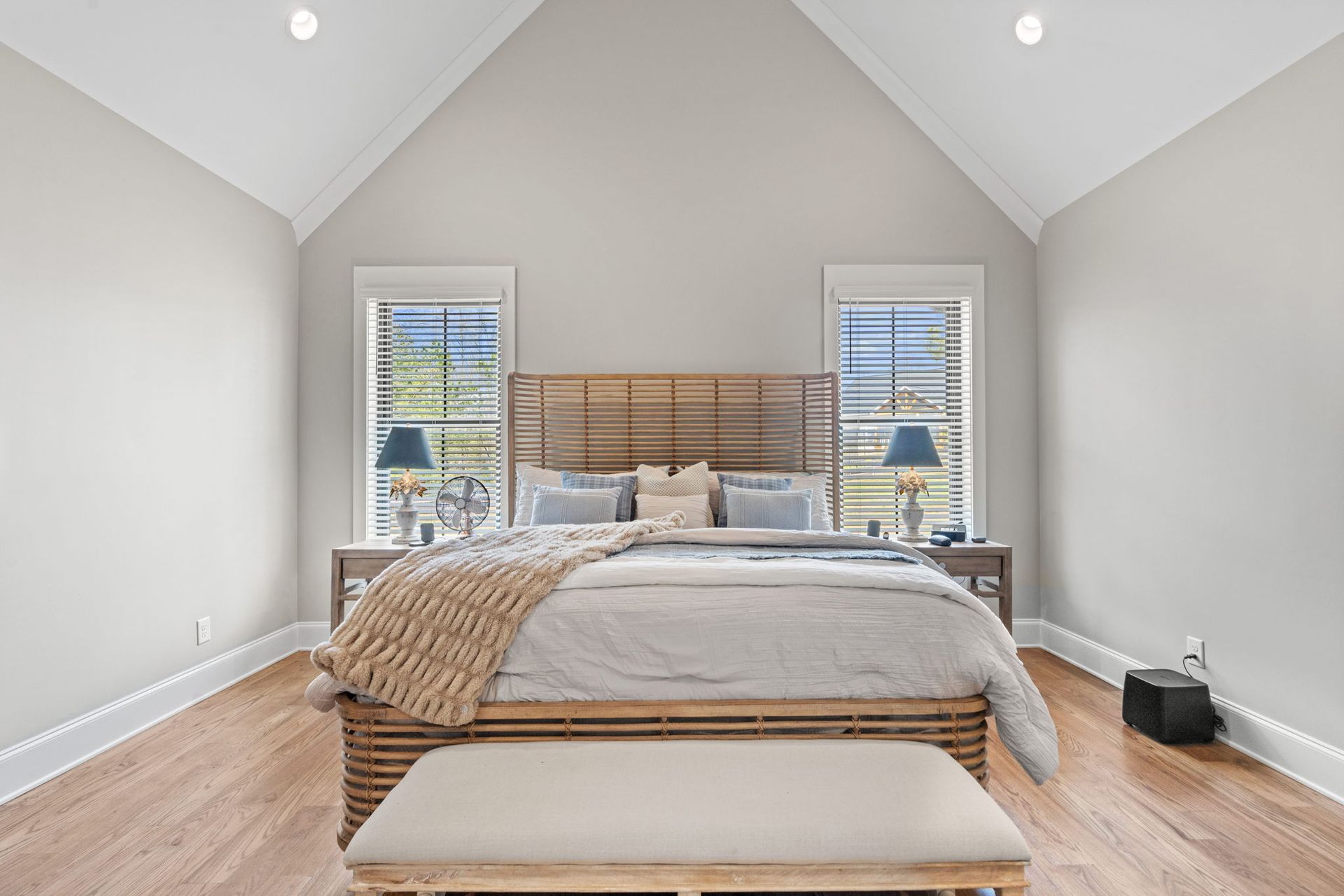 A bedroom with a vaulted ceiling and a large bed
