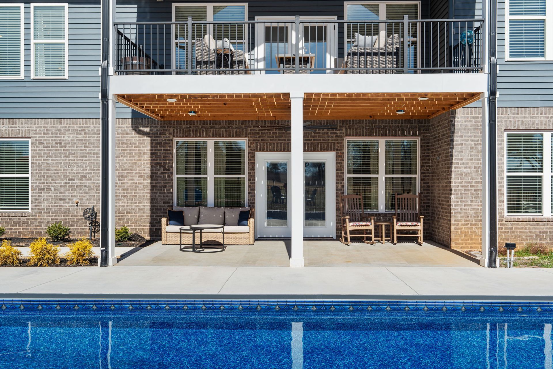 A large house with a large swimming pool in front of it.