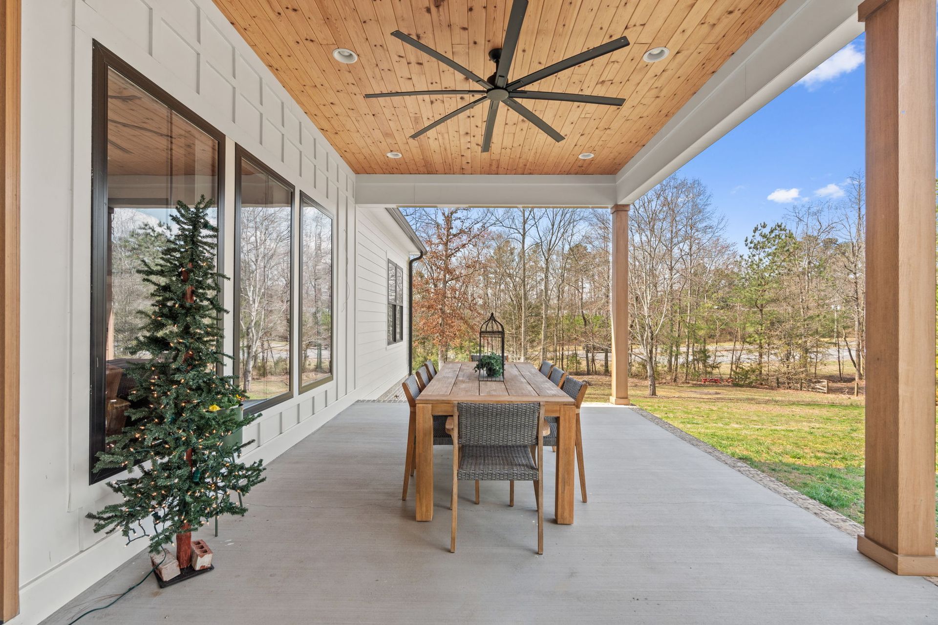 A patio with a table and chairs and a ceiling fan.