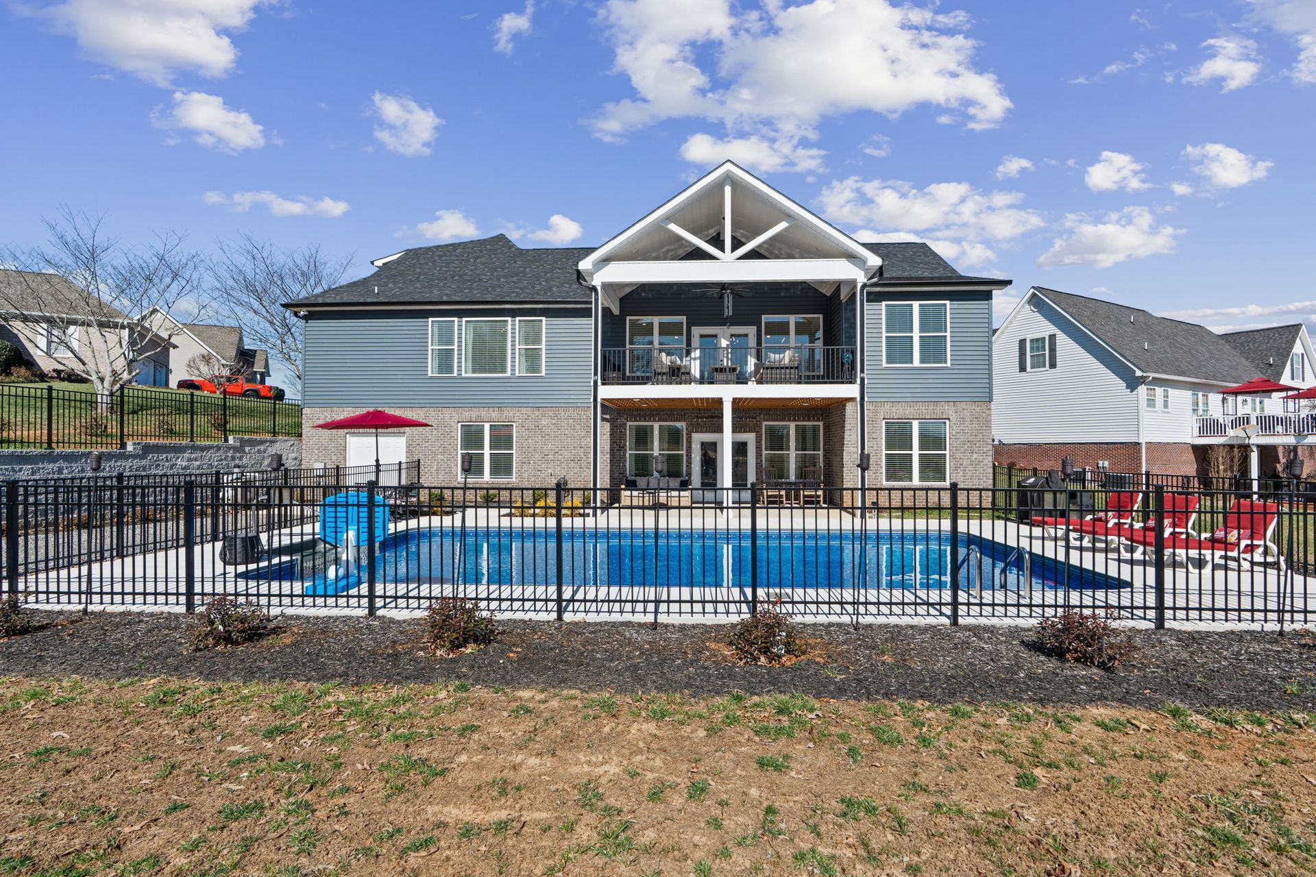 A large house with a large swimming pool in front of it.