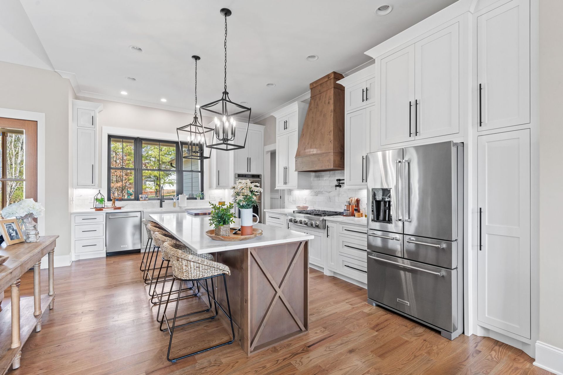A kitchen with white cabinets , stainless steel appliances , and a large island.