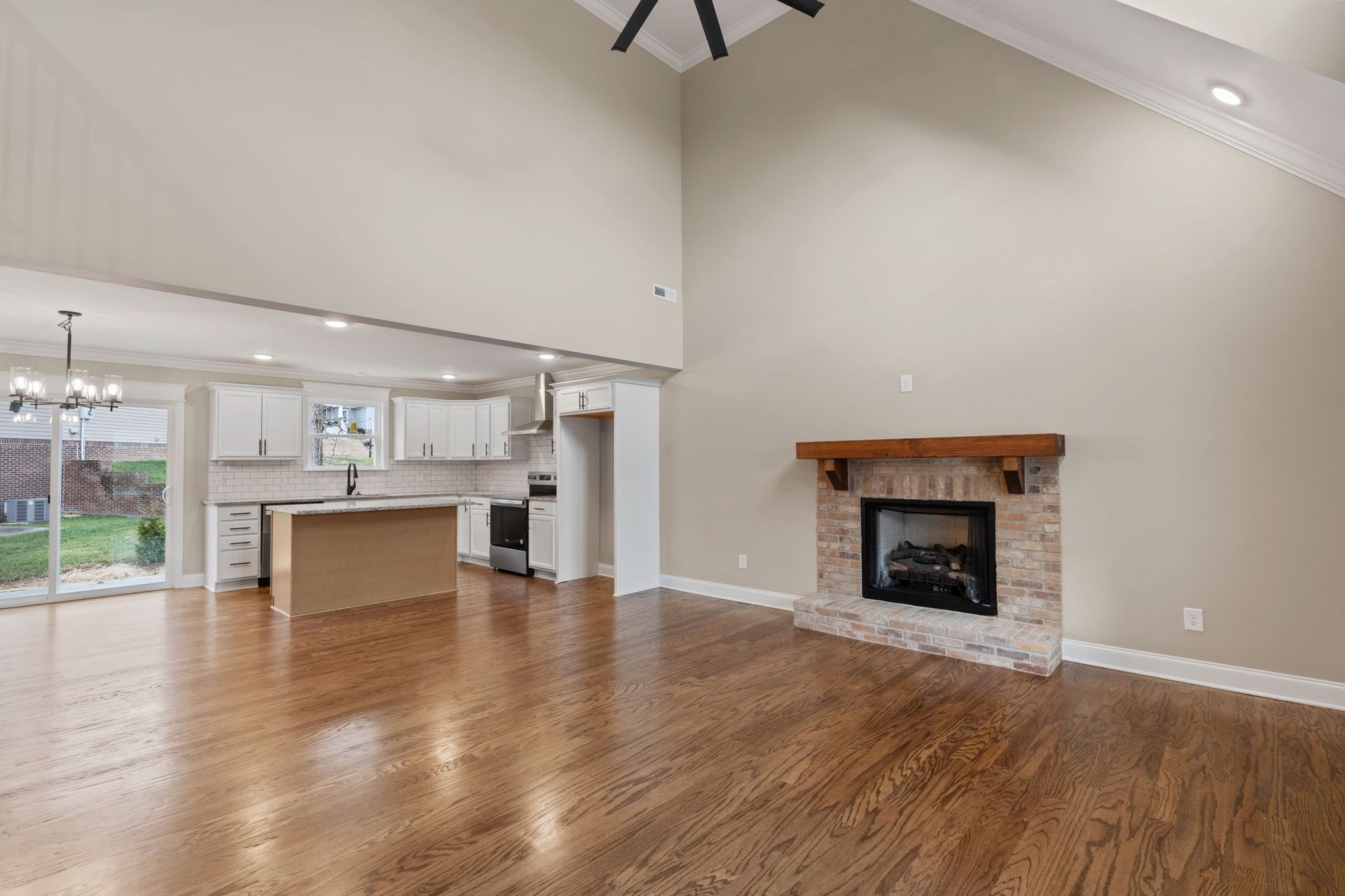 An empty living room with hardwood floors and a fireplace.