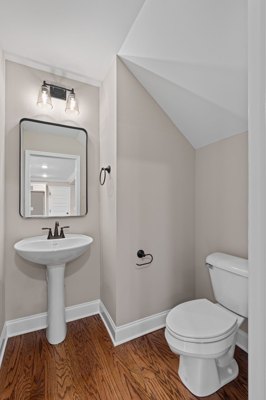 A bathroom with a sink , toilet and mirror.