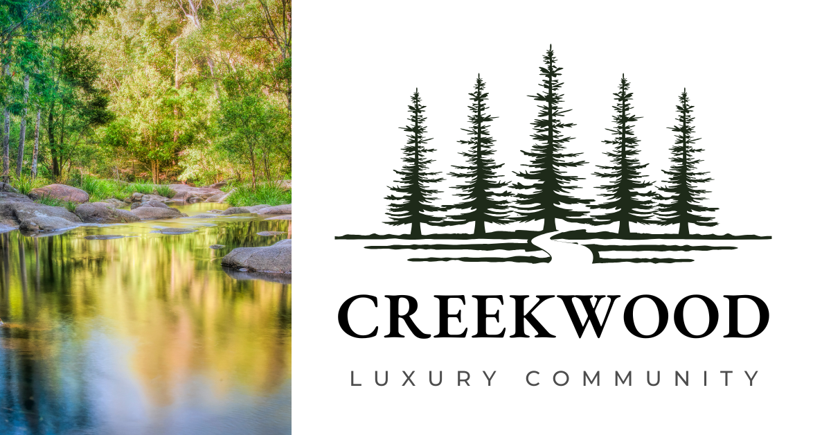 A logo for creekwood luxury community with a river and trees in the background.