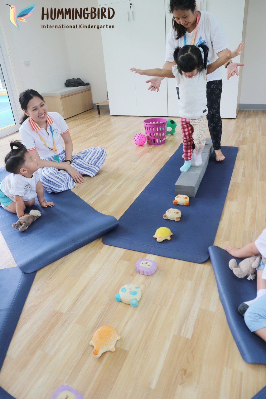 A group of children are playing on yoga mats in a room.
