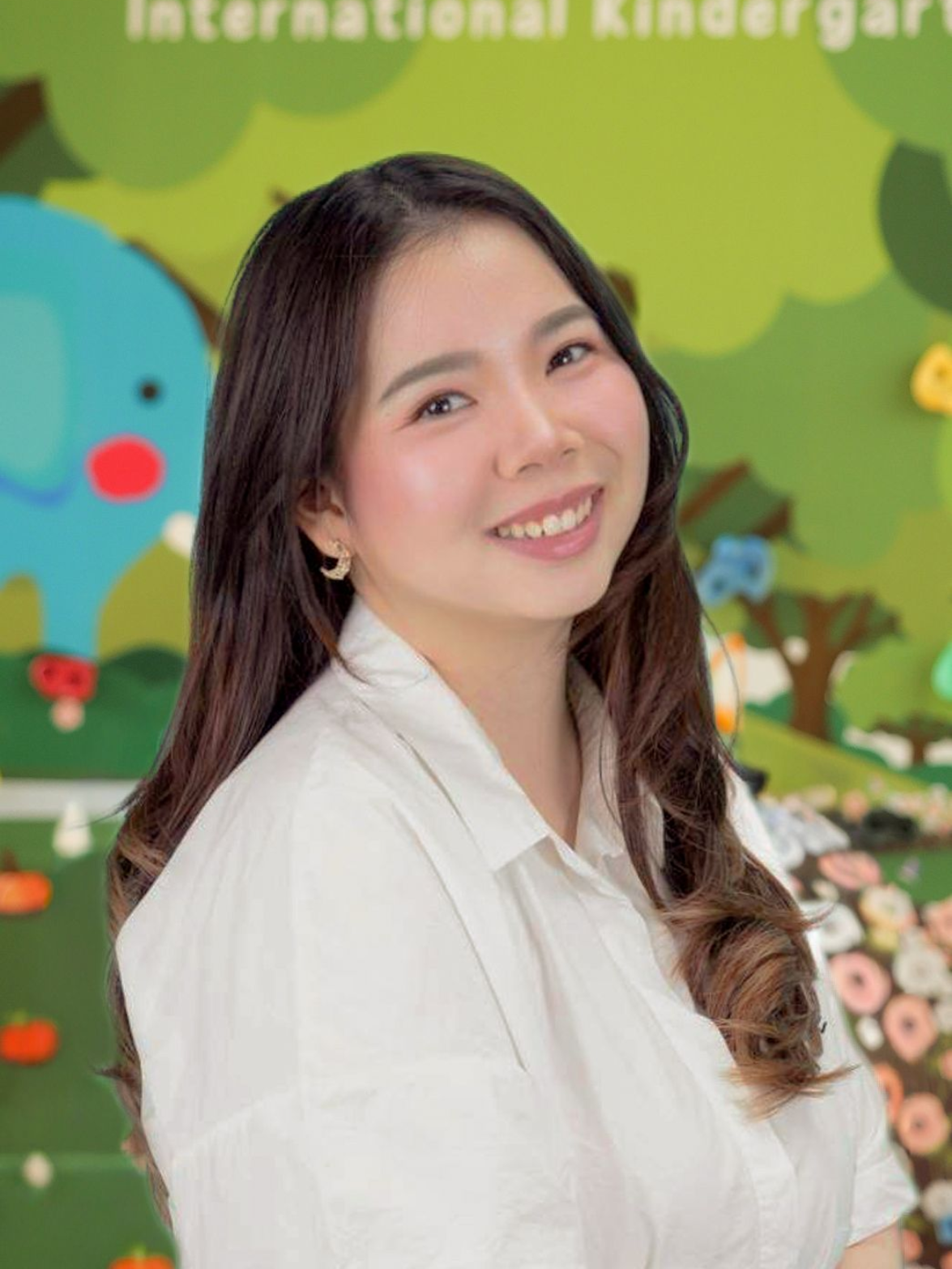 A woman is smiling for the camera in front of a palm tree.