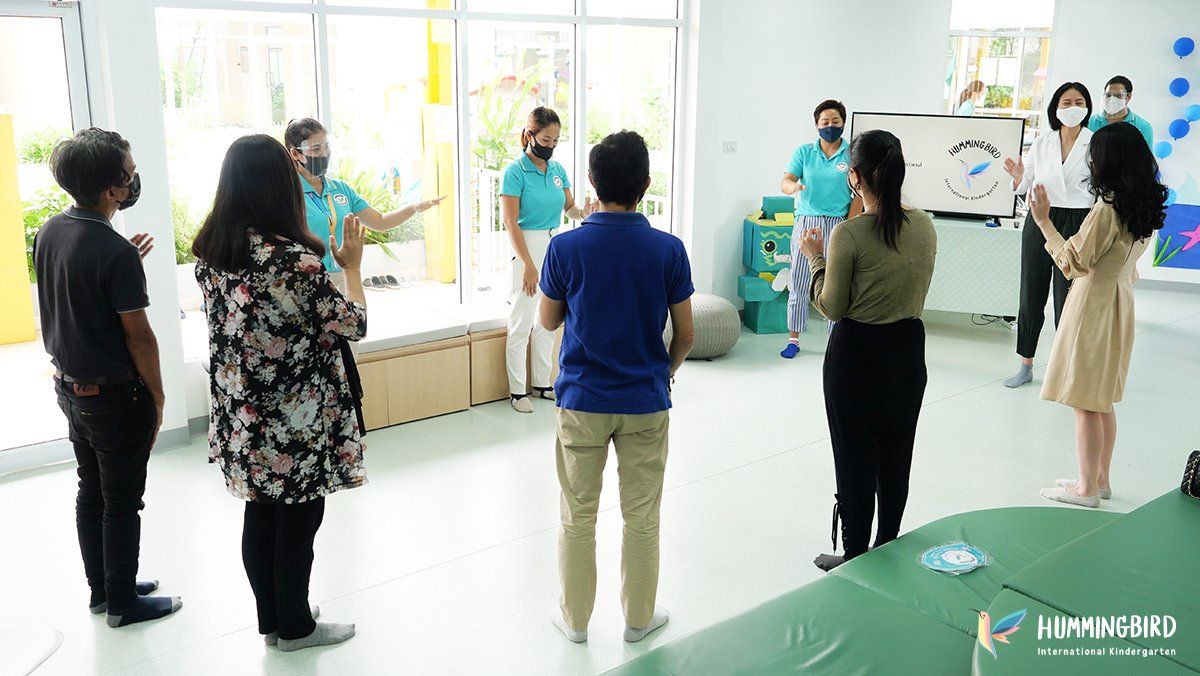 A group of people are standing in a circle in a room.
