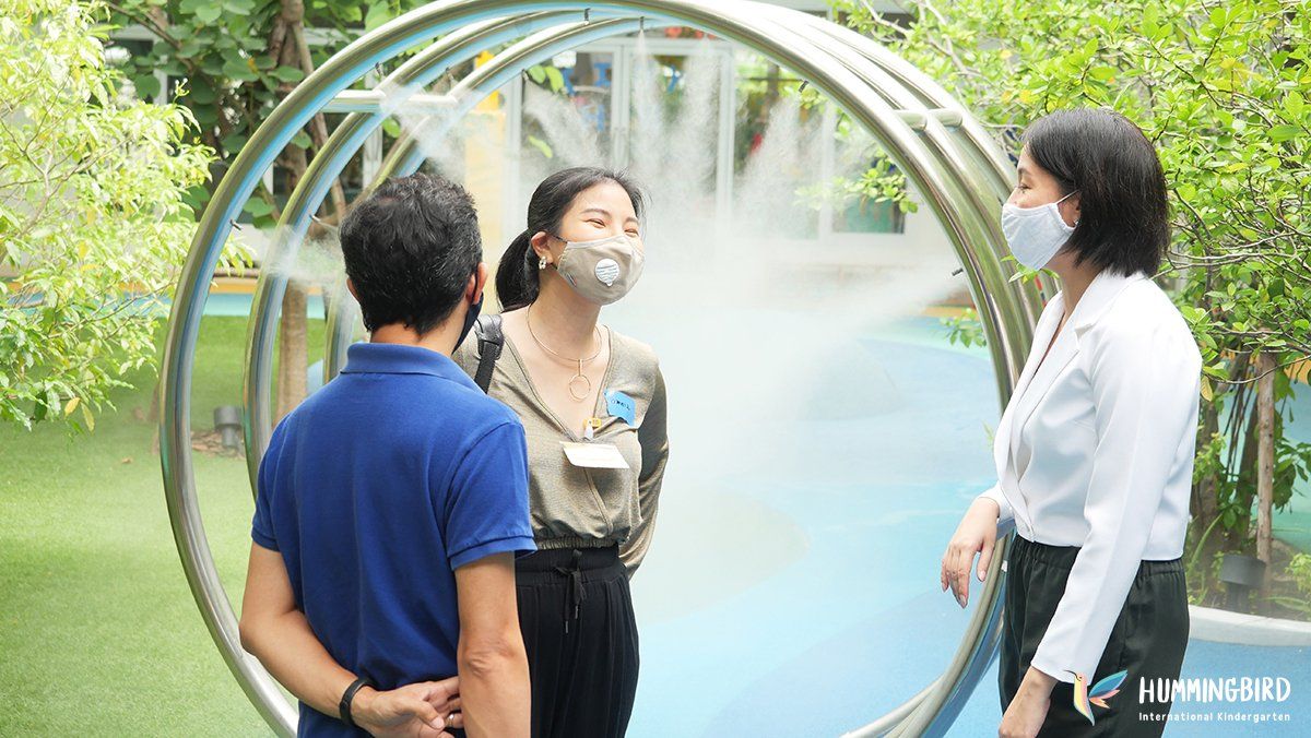 A group of people wearing face masks are standing in front of a circular structure.