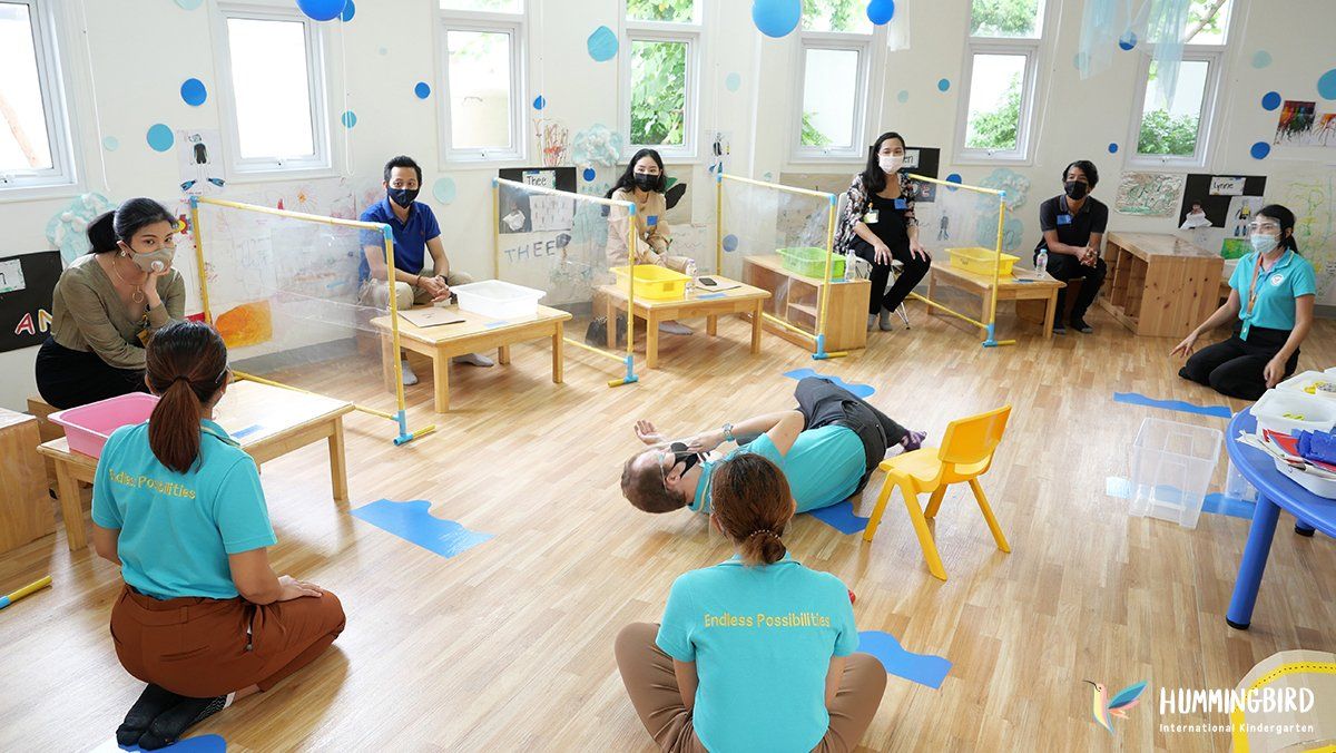 A group of people are sitting on the floor in a classroom.