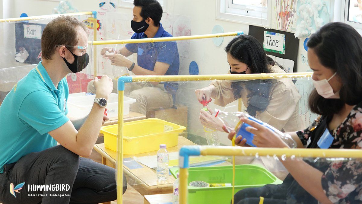 A group of people wearing masks are sitting at a table.