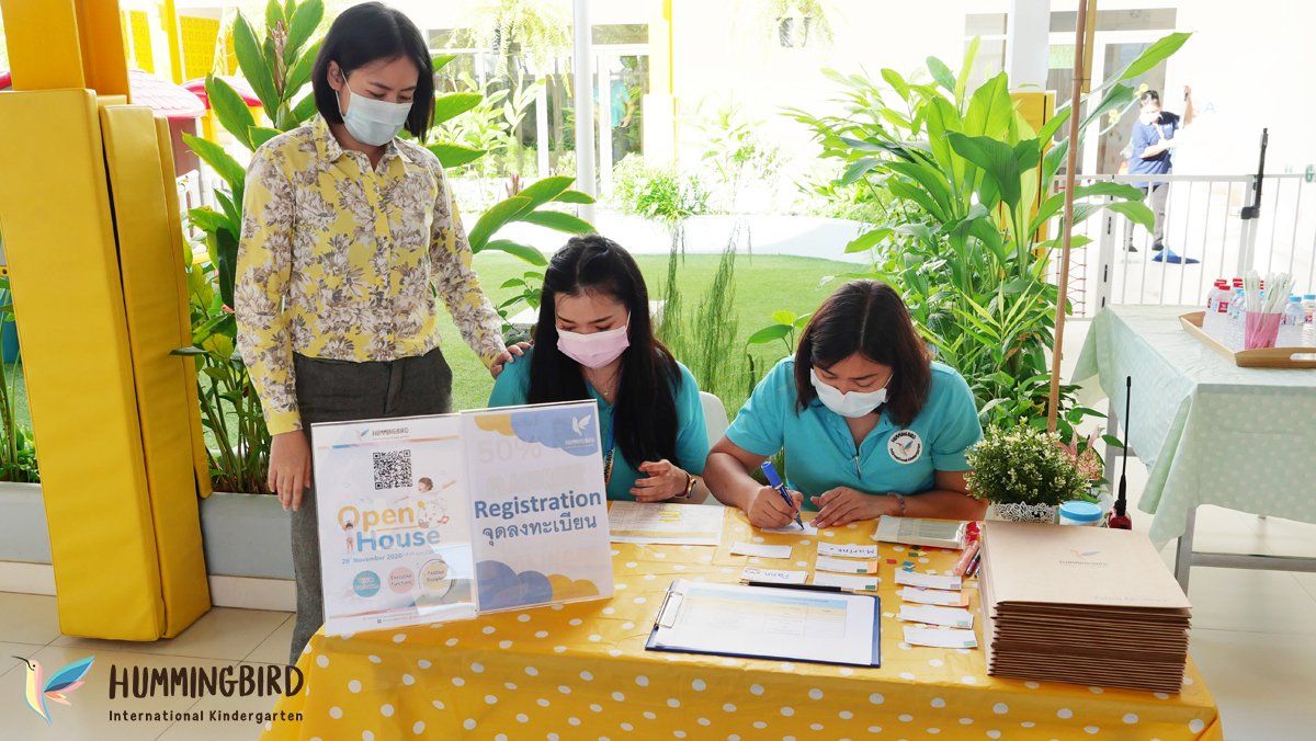 Three women wearing face masks are sitting at a table.