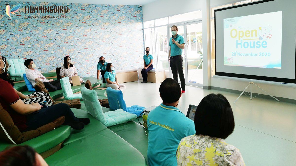 A group of people are sitting in chairs in front of a projector screen.