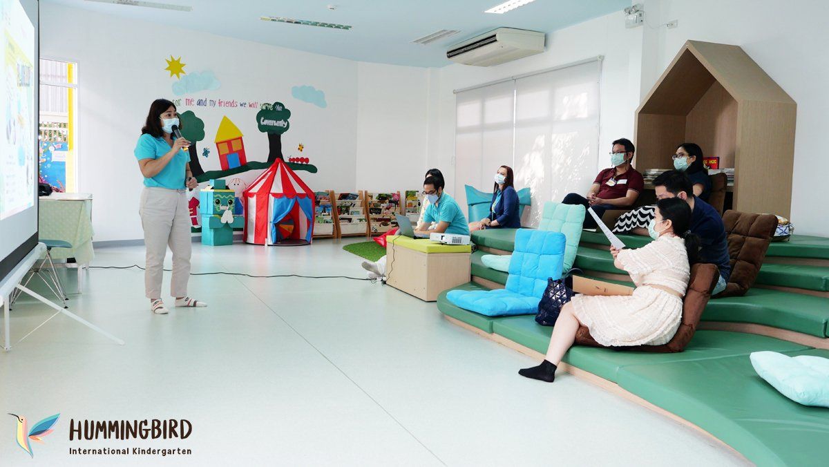 A woman is giving a presentation to a group of people in a room.