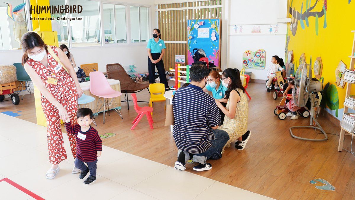 A group of people are playing with a baby in a classroom.