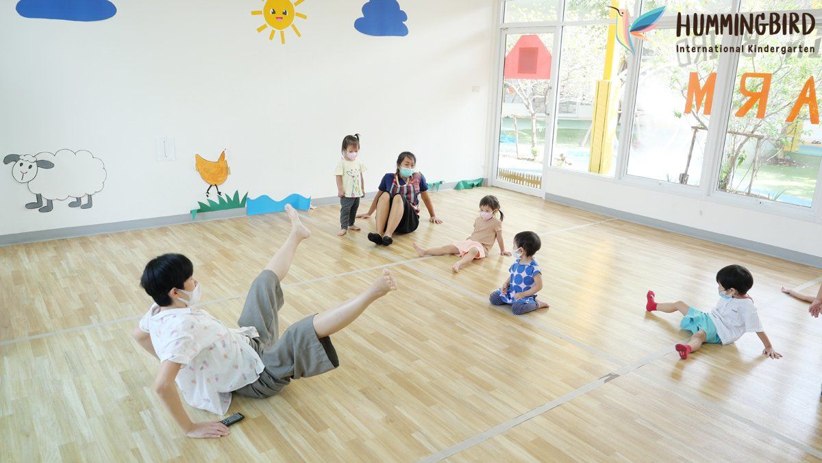 A group of children are sitting on the floor in a room.