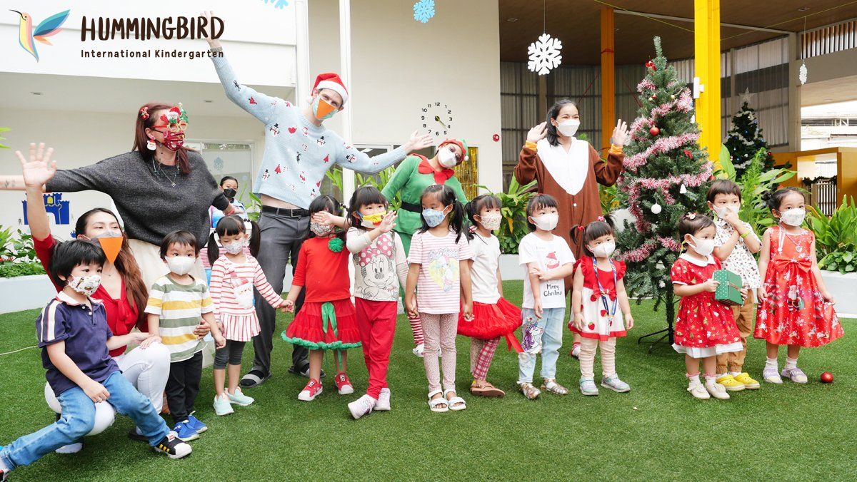 A group of children are posing for a picture in front of a christmas tree.