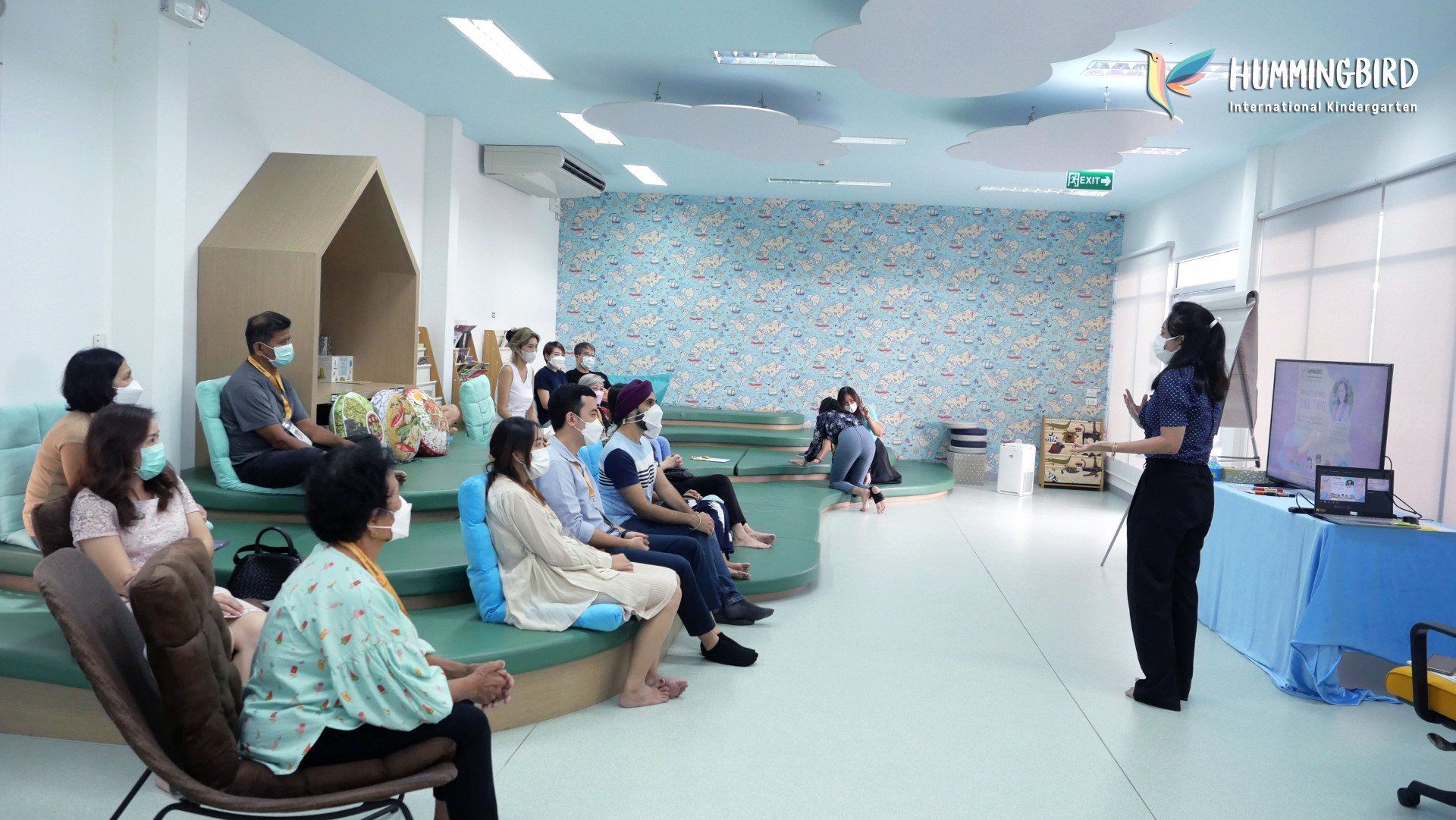 A woman is giving a presentation to a group of people sitting in chairs.