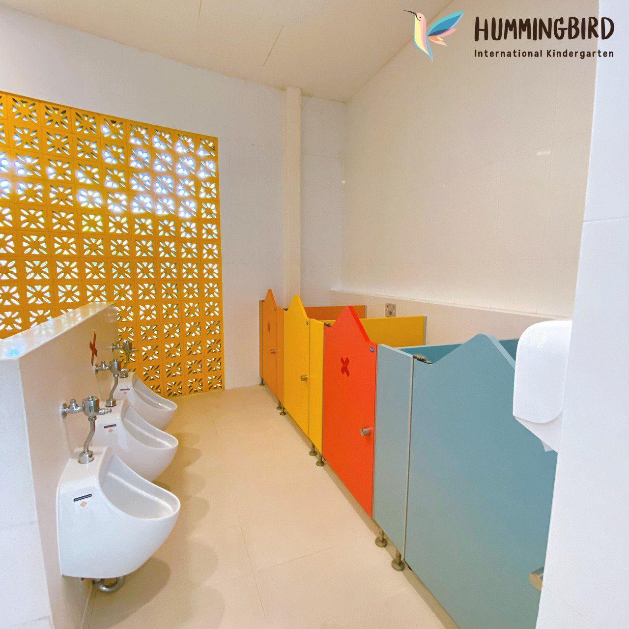 A bathroom with a hummingbird logo on the wall