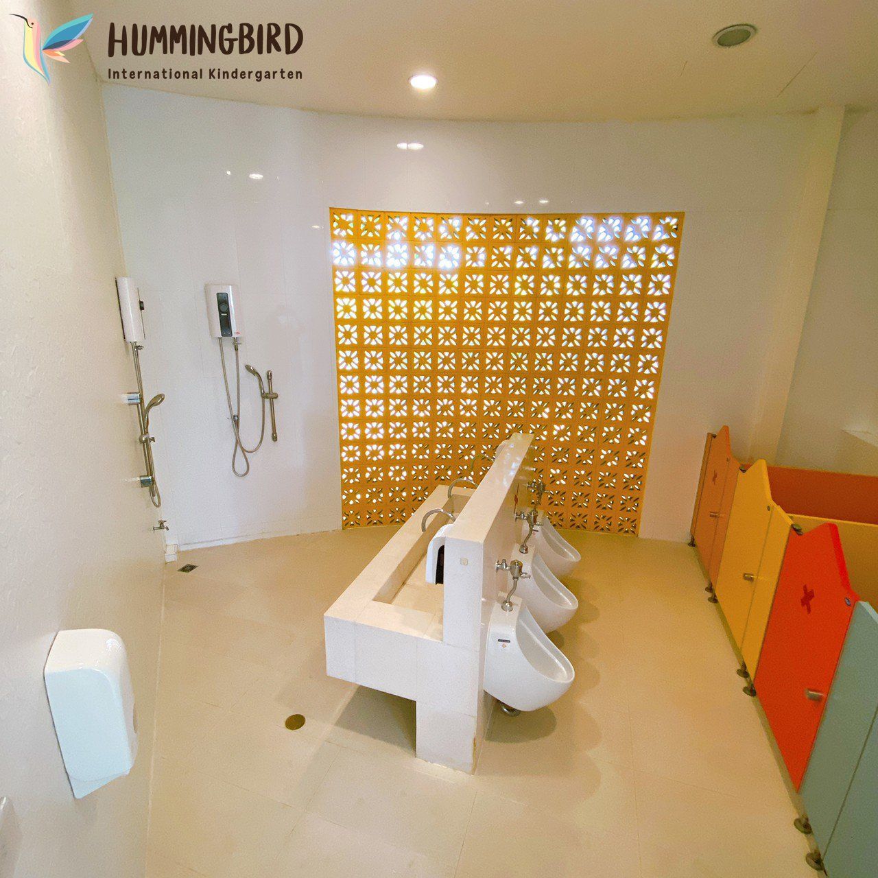 A bathroom with a hummingbird logo on the wall