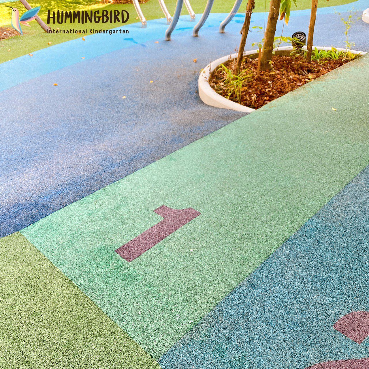 A hummingbird logo is on the side of a playground