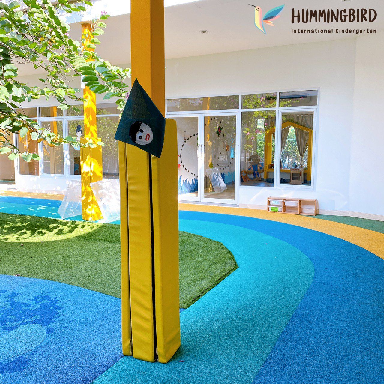 A yellow pole with a hummingbird logo on it