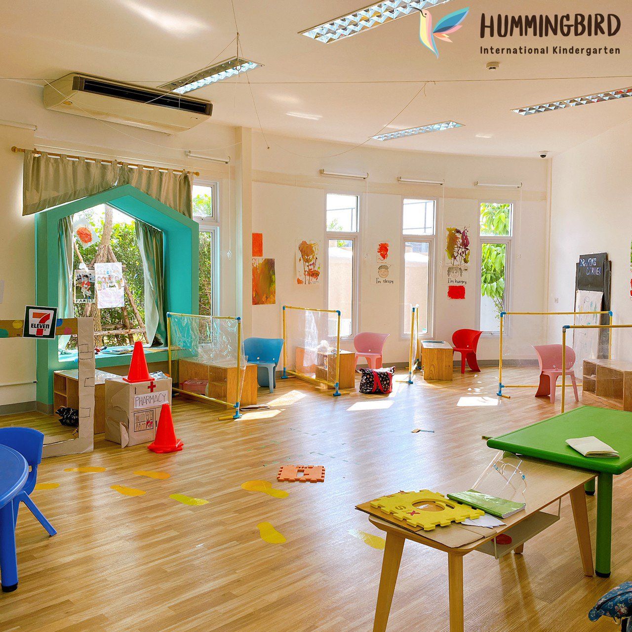 A large room with a hummingbird logo on the ceiling