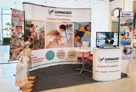 A booth in a mall with a table and a tv.