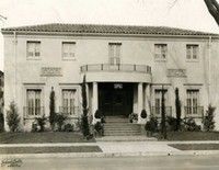 a black and white photo of a large house with stairs leading up to the front door . Current location of W.F Gormley & Sons Funeral Chapel