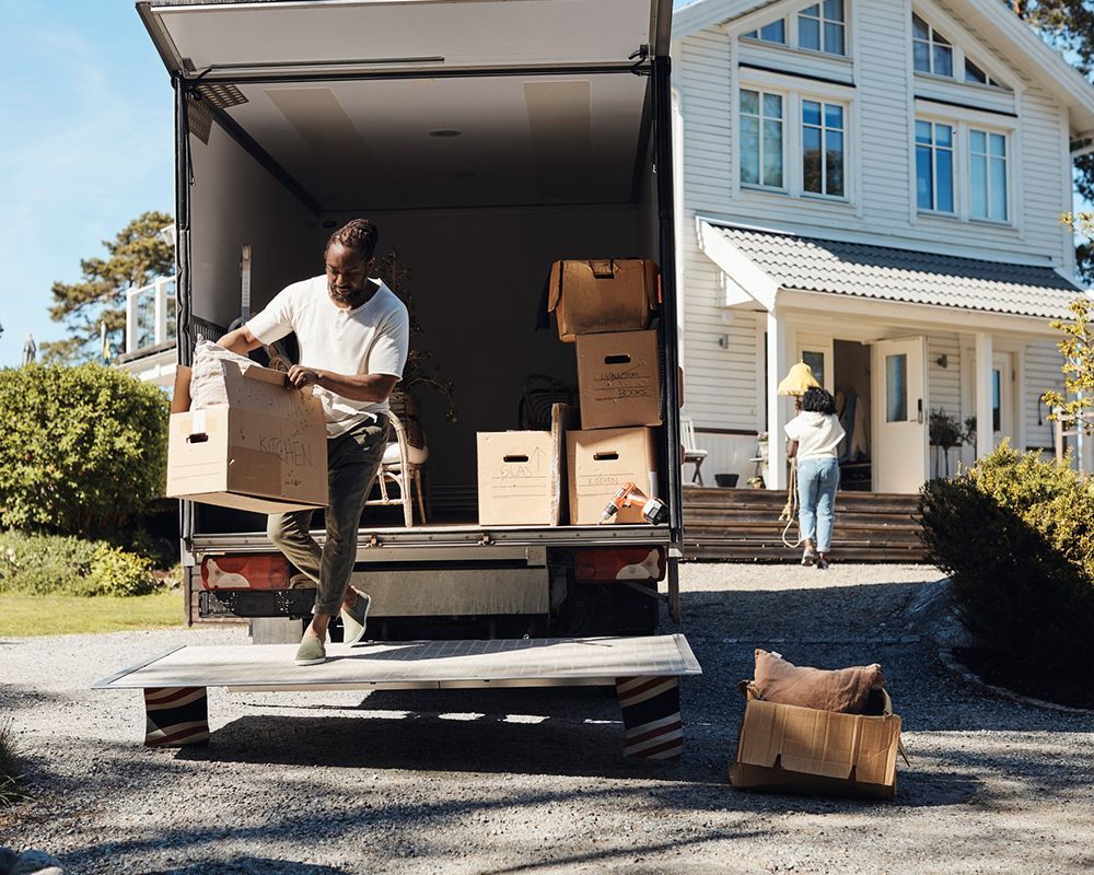 Worker Unloading Cardboard Box from a Van — Worthington, MN — Schaap Moving & Storage