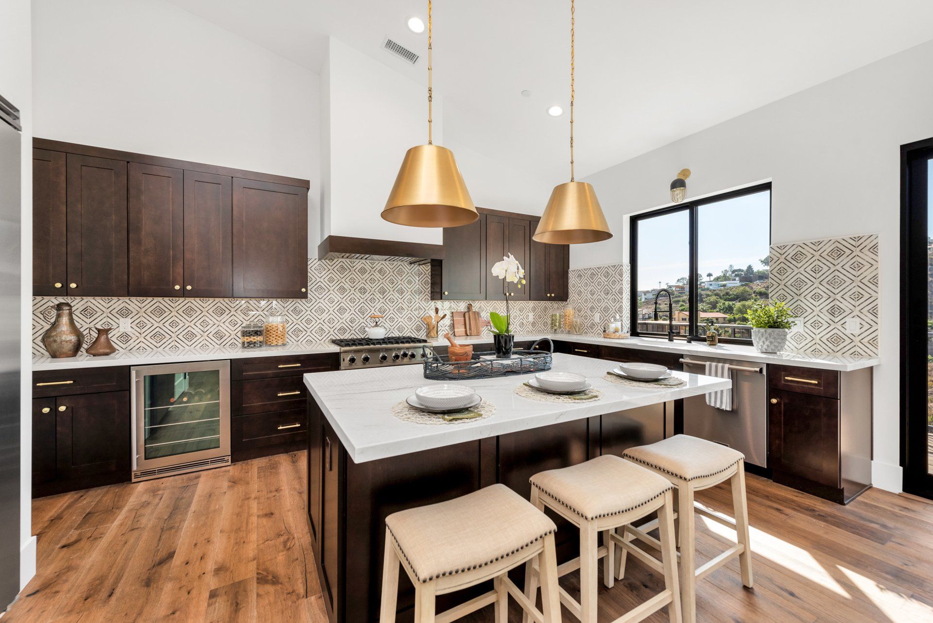 A kitchen with a large white island and stools.