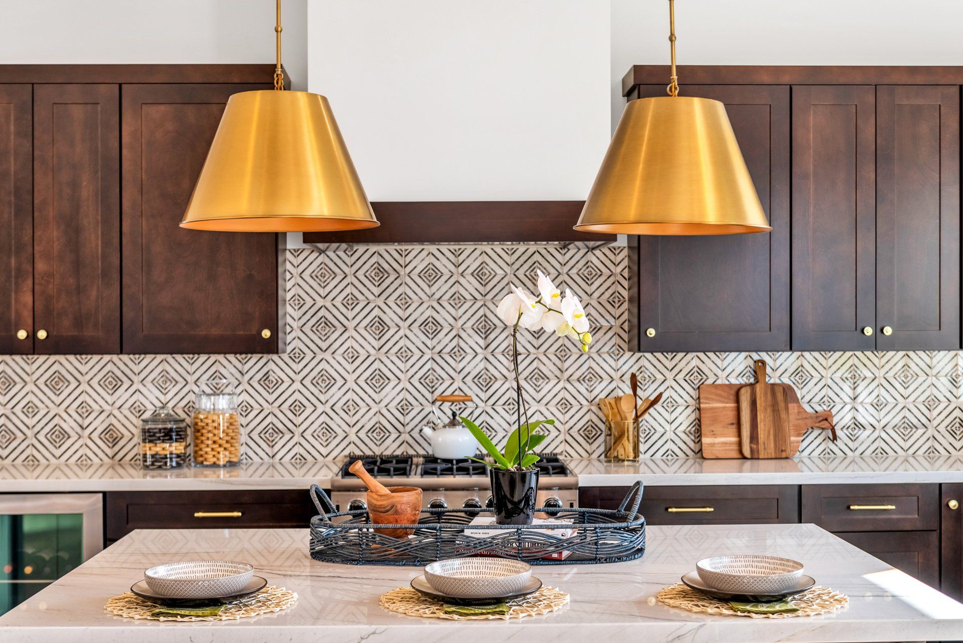 A kitchen with wooden cabinets, a stove top oven, and a large island.