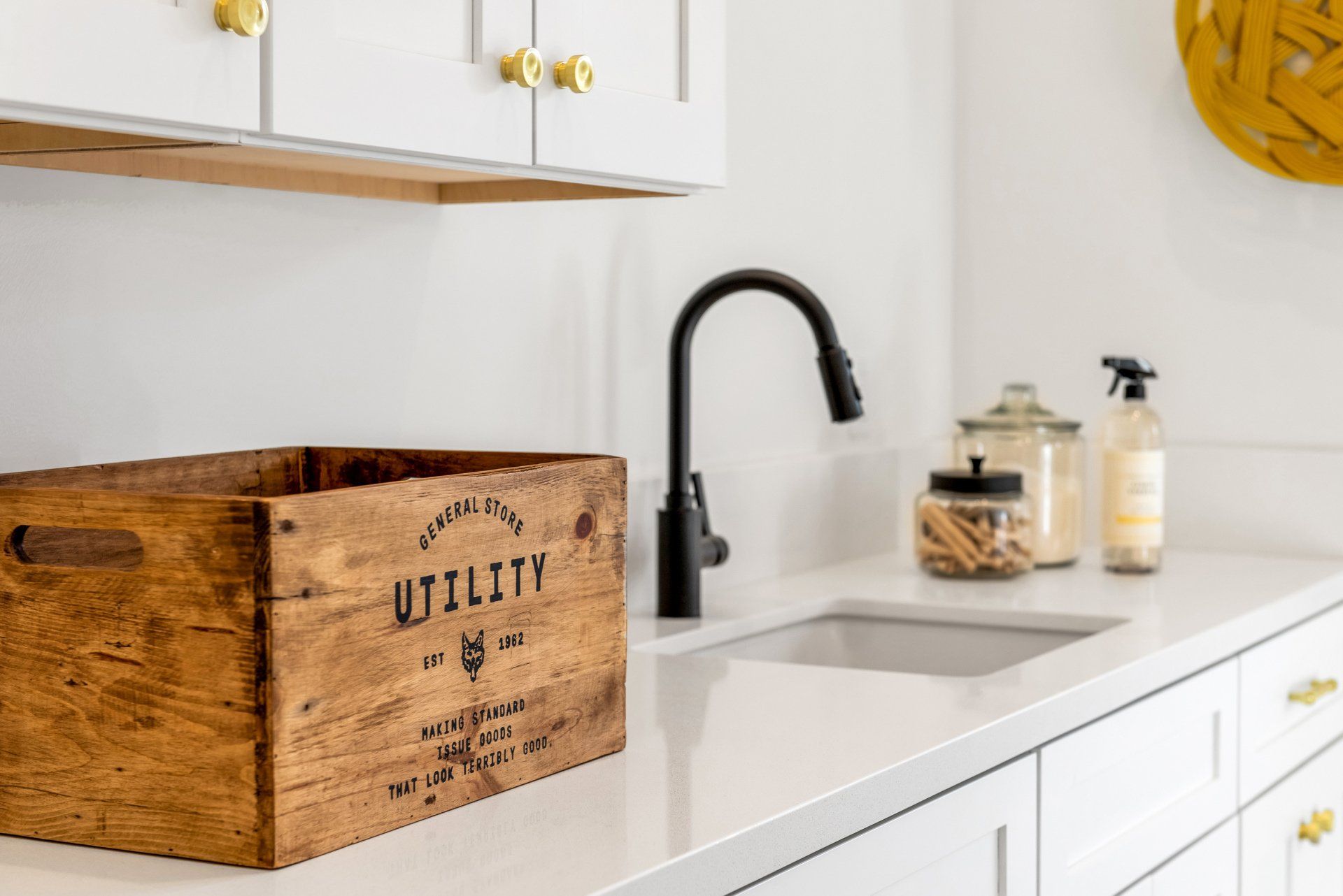 A wooden utility box is sitting on a white kitchen counter next to a sink.
