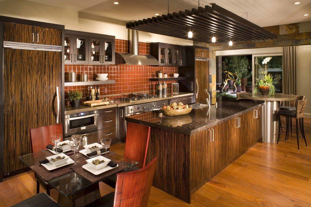 A kitchen with stainless steel appliances, wooden cabinets, and black granite countertops.