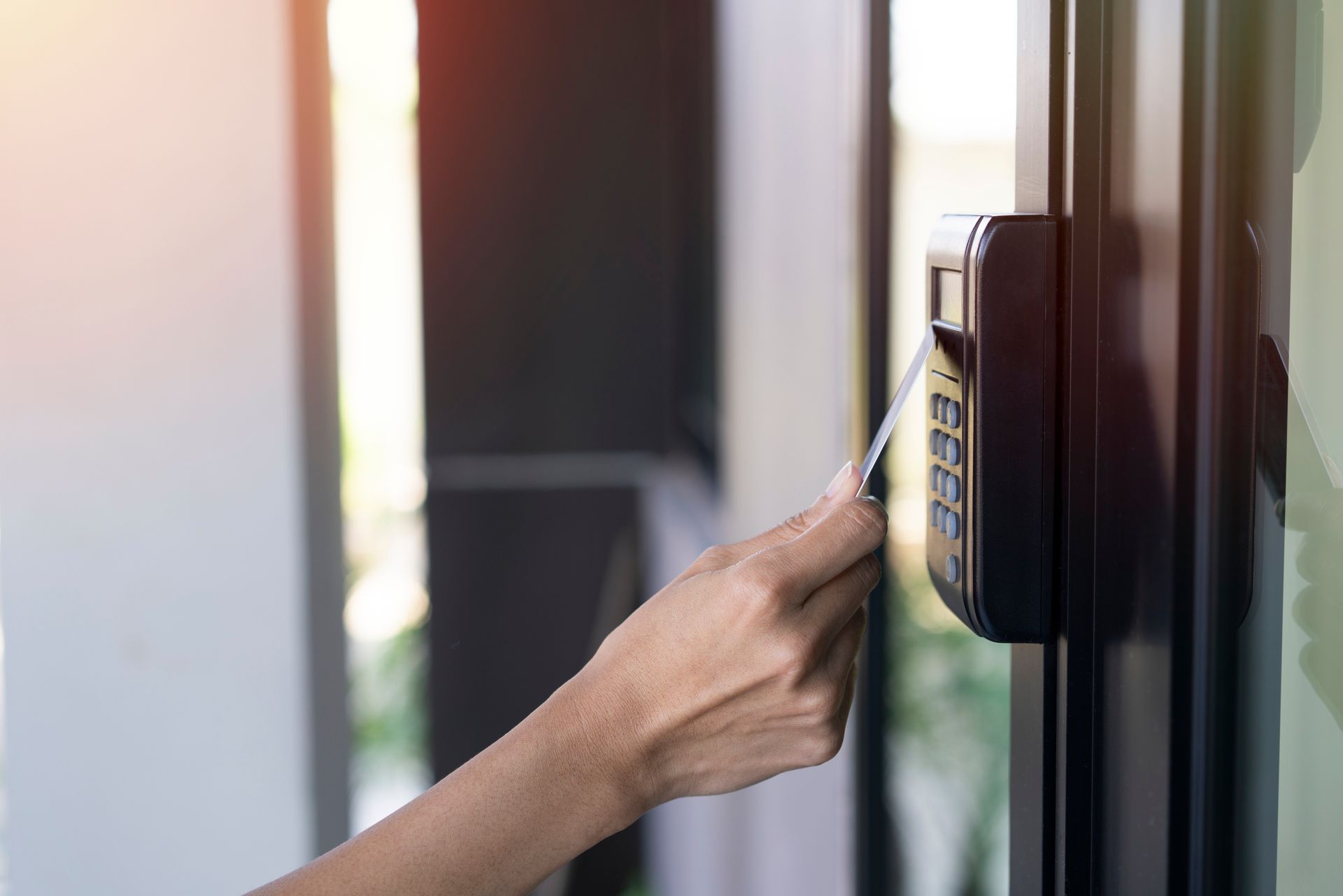 Woman using RFID tag key card, fingerprint, and access control to open a door in an office building.