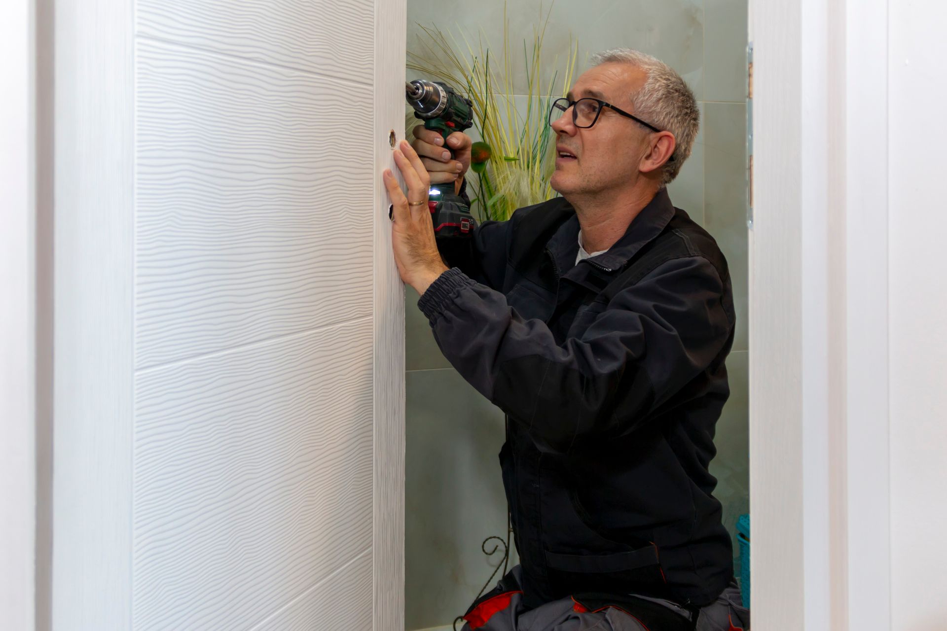 A man is installing a new lock. A man is installing a new lock.