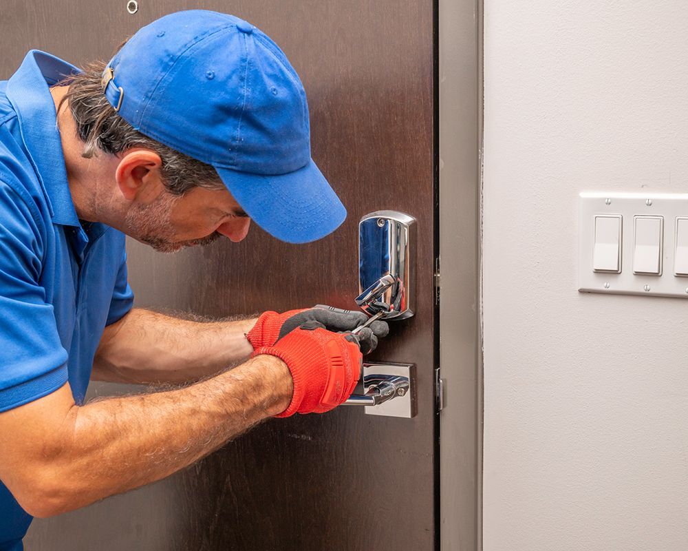 A locksmith from Shaw's Lock Service in Englewood, NJ, working on a deadbolt lock.