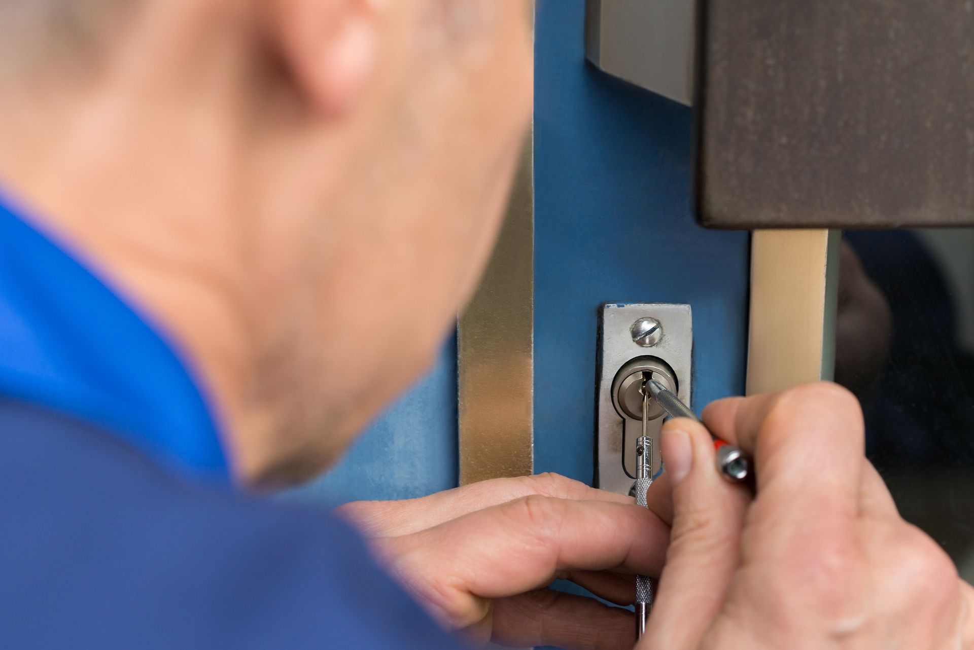 Close-up of a male locksmith repairing a door in Fort Lee, NJ, provided by Shaw's Lock Service.