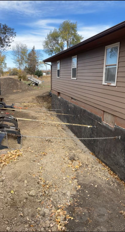 A house is being built in the middle of a dirt field.