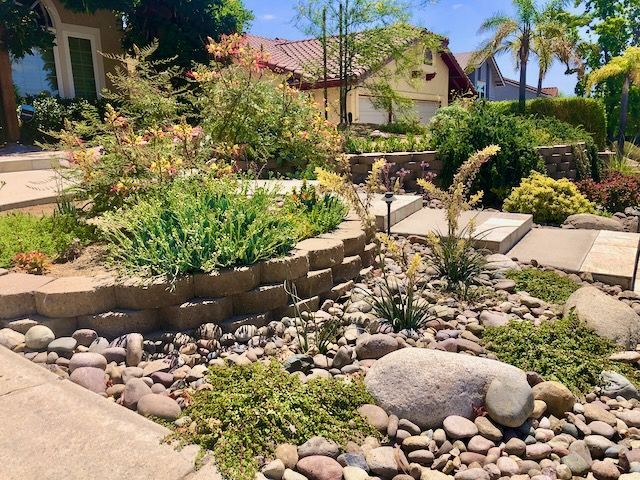 A Poway Residential Home's front yard garden with rocks and plants in front of a house