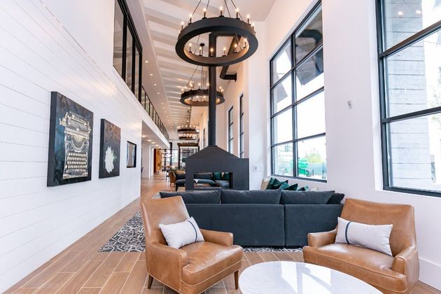 A living room with a couch , chairs , a table and a fireplace.