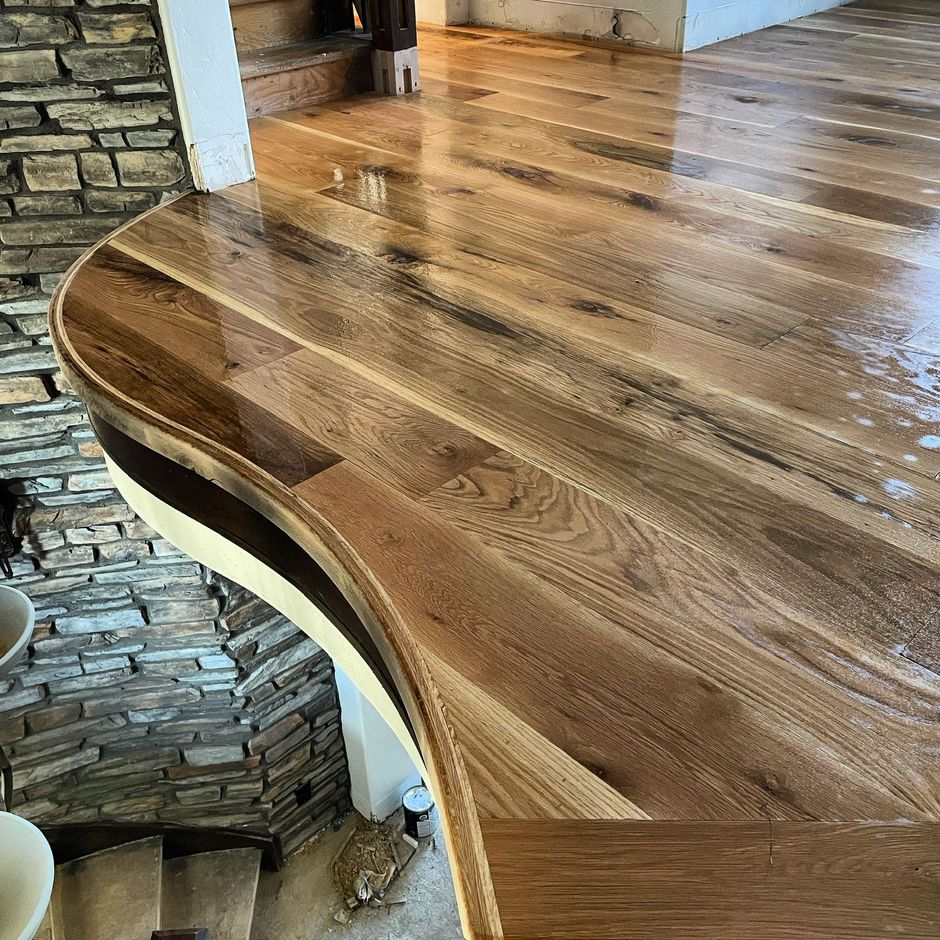 A wooden floor with a brick wall in the background