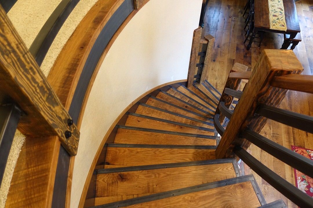 A spiral staircase made of wood and metal in a house.